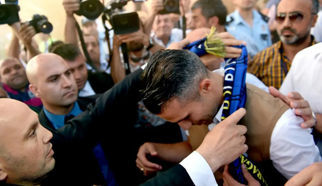 Pendukung Fenerbahce memberikan syal kepada Van Persie tiba di bandara Sabiha Gokcan, Istanbul, Turki, (12/7/2015). Informasi yang beredar Van Persie akan dikontrak selama tiga tahun oleh Fenerbahce. (AFP PHOTO/Ozan Kose)