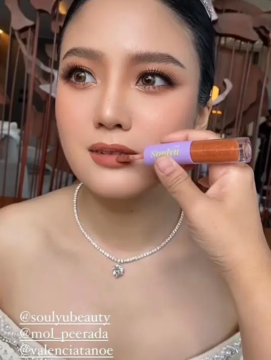 Sementara bibirnya dipoles dengan lipstik matte dengan teknik overdrawn lips untuk memberi kesan bibir lebih penuh dan merona.