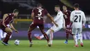 Striker AC Milan, Ante Rebic (tengah) melepaskan umpan di antara dua pemain Torino dalam laga lanjutan Liga Italia 2020/2021 pekan ke-36 di Olympic Stadium, Turin, Rabu (12/5/2021). AC Milan menang 7-0 atas Torino. (LaPresse via AP/Spada)