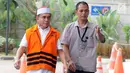 Gubernur Aceh Irwandi Yusuf memakai rompi oranye dikawal petugas saat tiba untuk turun dari mobil tahanan tiba untuk menjalani pemeriksaan lanjutan di gedung KPK, Jakarta, Rabu (25/7). (Merdeka.com/Dwi Narwoko)