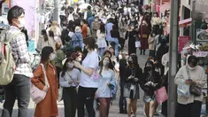 Orang-orang yang memakai masker wajah untuk melindungi dari penyebaran virus corona berjalan di sebuah jalan di Tokyo, Rabu (31/3/2021).  Ibukota Jepang mengonfirmasi lebih dari 410 kasus virus corona baru pada hari Rabu. (AP Photo/Eugene Hoshiko)