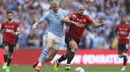 Pemain Manchester United, Sofyan Amrabat (kanan) berebut bola dengan pemain Manchester City, Erling Haaland saat laga final Piala FA 2023/2024 di Stadion Wembley, London, Sabtu (26/05/2024). (AP Photo/Ian Walton)