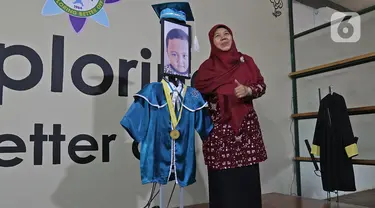 Kepala Sekolah berfoto dengan roboda (robot wisuda) saat wisuda virtual siswa Kelompok Bermain Taman Kanak-kanak (KB TK) Sekolah Nasional Satu di Bekasi, Rabu (1/07/2020). Sekolah menggunakan teknologi virtual dan roboda guna memudahkan prosesi wisuda selama Covid-19.(Liputan6.com/Herman Zakharia)