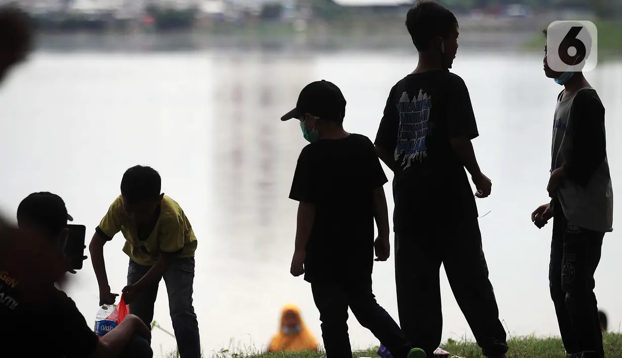 Anak-anak bermain di Taman Kota Waduk Pluit di Penjaringan, Jakarta Utara, Minggu (27/12/2020). Taman Kota Waduk Pluit dibuka kembali setelah di tutup pada libur Natal, namun banyak warga yang berwisata tidak menerapkan protokol kesehatan. (Liputan6.com/Johan Tallo)