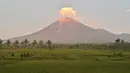 Gunung Semeru menyemburkan asap tipis terlihat dari desa Curah Kobokan di Lumajang, Jawa Timur, Rabu (8/12/2021).  Usai meletus pada Sabtu 4 Desember 2021, Gunung Semeru yang terletak di Lumajang tersebut berstatus level 2 waspada. (ADEK BERRY / AFP)