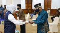 Gubernur Jatim, Khofifah Indar Parawansa memberikan tali asih secara simbolik kepada perwakilan seniman dan budayawan. (Foto: Liputan6.com/Dian Kurniawan)