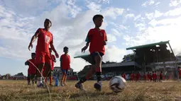 Pemain Malut United, Ridwan Tawainella, mendampingi anak-anak yang sedang berlatih passing saat kegiatan&nbsp;coaching clinic di Stadion Gelora Kie Raha, Ternate, Minggu (13/8/2023) sore hari WIT. (Bola.com/Okie Prabhowo)