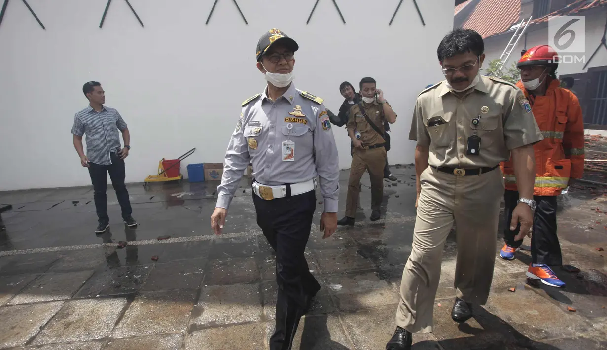 Gubernur DKI Jakarta Anies Baswedan berbincang dengan pejabat Pemprov DKI Jakarta saat meninjau lokasi kebakaran Museum Bahari, di Jalan Pasar Ikan, Penjaringan, Jakarta Utara, Selasa (16/1). (Liputan6.com/Arya Manggala)