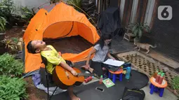 Aktivitas warga saat work from home di halaman rumahnya di kawasan Cinere, Depok, Senin (23/3/2020). Imbauan pemerintah untuk bekerja dari rumah atau work from home untuk mencegah penularan virus corona, dimanfaatkan warga dengan beragam aktivitas. (merdeka.com/Arie Basuki)