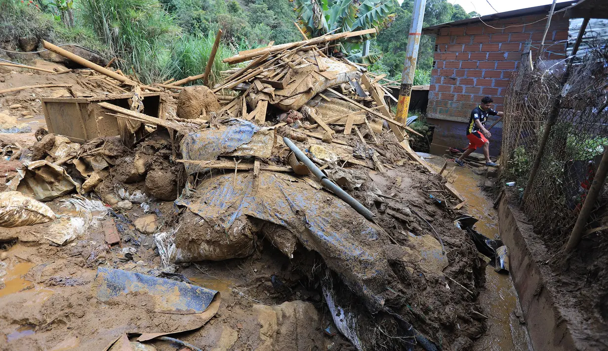 Seorang warga meninggalkan daerah tersebut setelah menerima perintah evakuasi menyusul tanah longsor di Bello, Distrik Antioquia, Kolombia, pada tanggal 25 Juni 2025. (JAIME SALDARRIAGA/AFP)