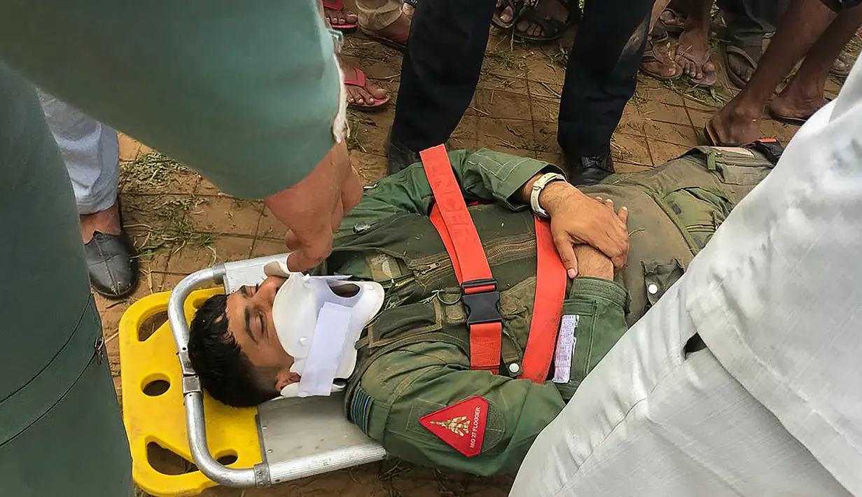 Pilot pesawat MiG-27 mendapatkan bantuan setelah pesawatnya jatuh saat misi rutin di sekitar desa Devariya dekat Jodhpur, India, (4/9). Menurut media lokal, tidak ada korban jiwa akibat insiden tersebut. (AFP Photo)