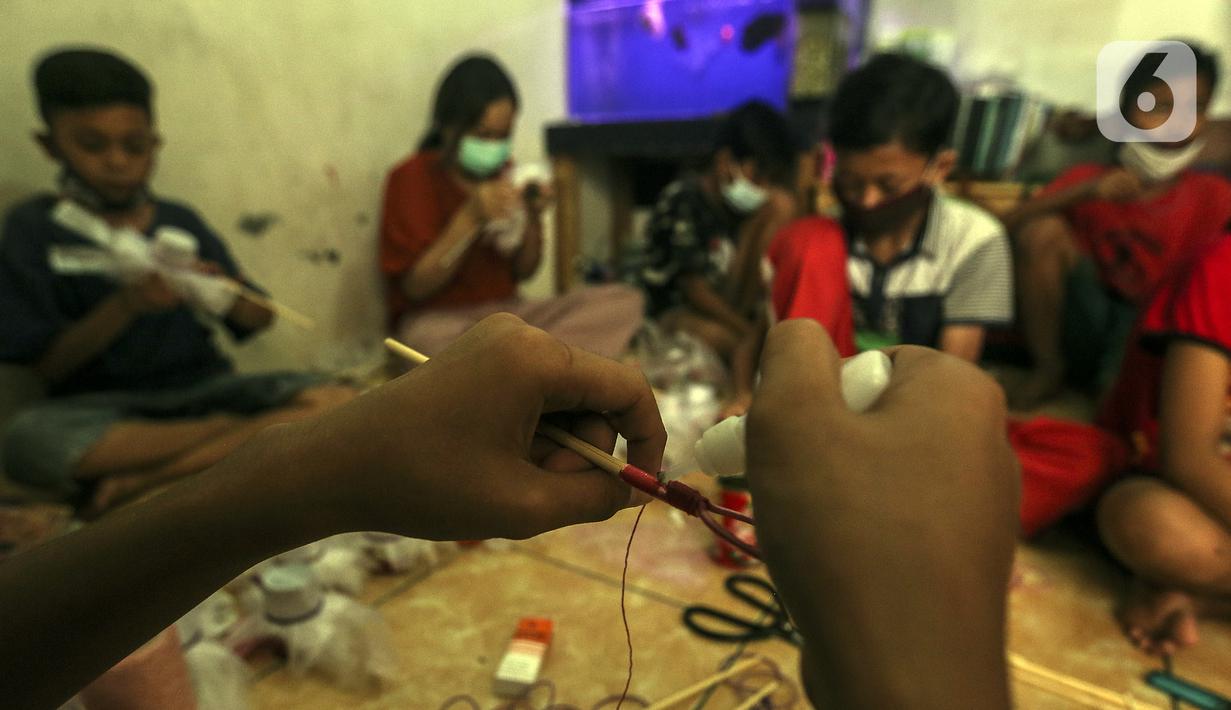 Anak-anak membuat serokan ikan cupang di rumah kontrakan Udin, Sukabumi Selatan, Jakarta Barat, Selasa (22/12/2020). Anak-anak yang ikut bekerja membuat serokan ikan cupang diberi uang jajan. (Liputan6.com/Johan Tallo)