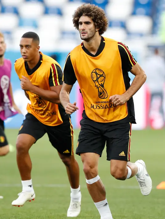 Gelandang Belgia, Marouane Fellaini melakukan pemanasan saat mengikuti latihan di stadion Kaliningrad,  Rusia (27/6). Belgia akan bertanding melawan Inggris pada grup G Piala Dunia 2018. (AP Photo/Alastair Grant)