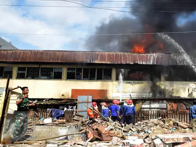 Petugas pemadam kebakaran berusaha memadamkan api yang membakar ruko di kompleks Kanjengan, Pasar Johar Semarang, Sabtu (18/6). Dugaan awal, kebakaran tersebut diakibatkan hubungan pendek arus listrik di salah satu toko di Blok E. (Liputan6.com/Gholib)