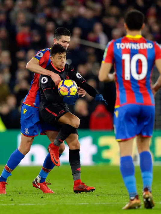 Striker Arsenal Alexis Sanchez berebut bola dengan pemain Crystal Palace Martin Kelly saat pertandingan Liga Inggris di stadion Selhurst Park di London (28/12). Dalam pertandingan ini Alexis Sanchez menyumbang dua gol. (AP Photo/Alastair Grant)