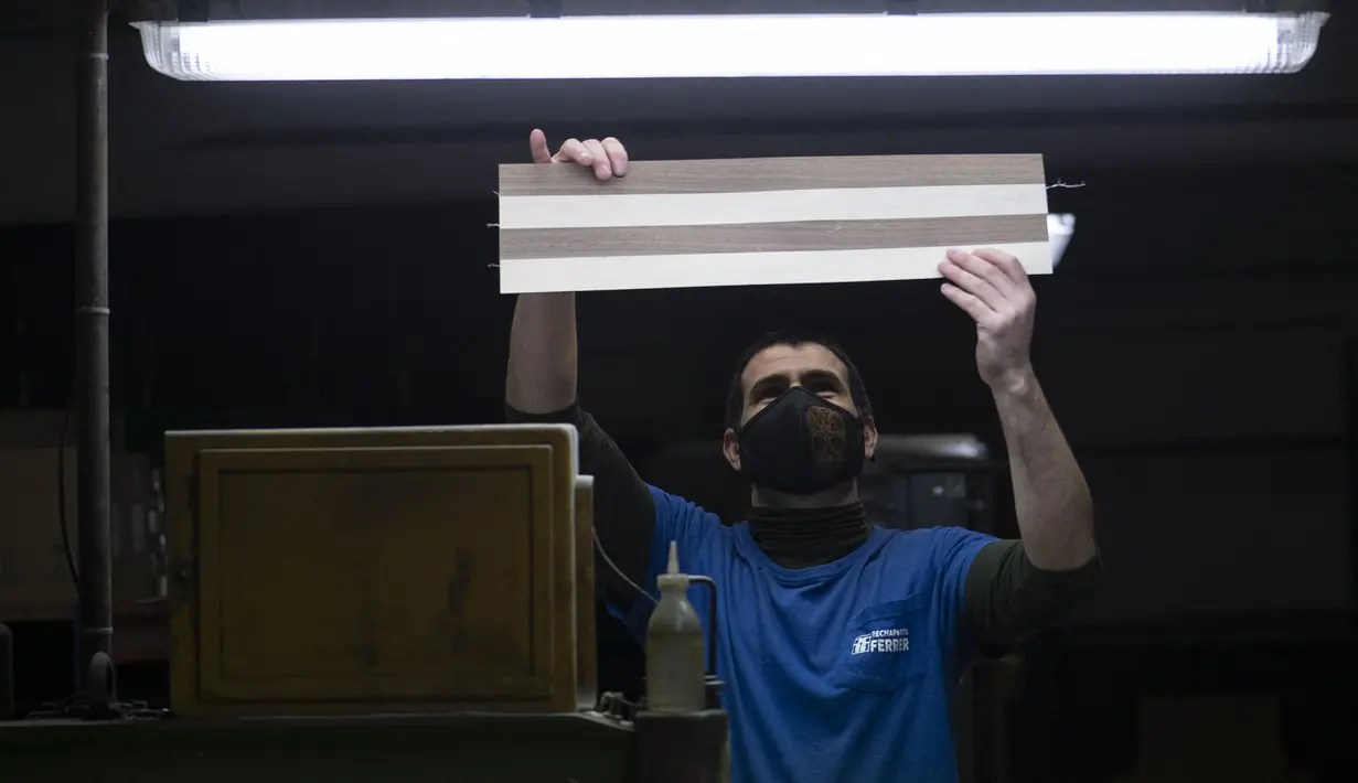 Karyawan Rechapados Ferrer mengecek papan catur di La Garriga dekat Barcelona (5/3/2021). Penjualan pembuat papan catur Spanyol itu melonjak sejak ditampilkan di serial Netflix terkenal "The Queen's Gambit". (AFP Photo/Josep Lago)