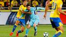 Pemain Barcelona Lionel Messi berebut bola dengan pemain Las Palmas, Rafael Castell pada jornada ke-26 La Liga 2017-2018 di Estadio Gran Canaria, Kamis (1/3). Barcelona gagal menang karena tuan rumah menahan imbang dengan skor 1-1. (AP/Lucas de Leon)