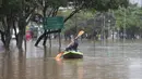 Seorang pria mendayung kayak di sepanjang jalan yang banjir di Sao Paulo, Brasil, Senin, (10/2/2020). Hujan deras yang membanjiri kota, menyebabkan pinggir sungai utama meluap. (AP Photo/Andre Penner)