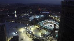 Pemandangan saat umat muslim melaksanakan sholat subuh pertama dalam bulan suci Ramadhan dengan menerapkan jaga jarak untuk membantu mengekang penyebaran virus corona COVID-19 di Masjidil Haram, Mekkah, Arab Saudi, Selasa (13/4/2021). (AP Photo/Amr Nabil)