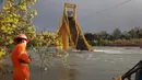Petugas evakuasi melihat kereta barang yang anjlok ke dalam Sungai Tolten setelah jembatan tersebut runtuh di Desa Pitrufquen, sabelah selatan Chili. (18/08). (REUTERS/Cristobal)