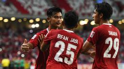 Bek Timnas Indonesia, Pratama Arhan (kiri) berselebrasi dengan rekan setimnya usai mencetak gol ke gawang Singapura pada pertandingan leg kedua semifinal Piala AFF 2020 di National Stadium, Sabtu (25/12/2021). Indonesia akan bertemu antara Thailand dan Vietnam di babak final. (AFP/Roslan Rahman)