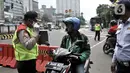 Petugas memberhentikan pengendara motor tanpa mengenakan masker di kawasan Menteng, Jakarta, Senin (13/4/2020). Batas maksimal 50 persen dari kapasitas kendaraan roda empat, berkendara dalam keadaan sakit, dan batas operasional kendaraan umum hingga pukul 18.00 WIB. (merdeka.com/Iqbal S. Nugroho)