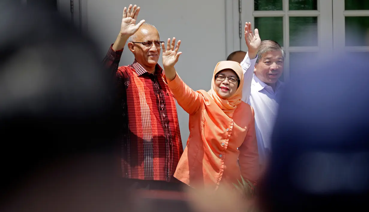 Halimah Yacob melambaikan tangan saat tiba untuk menyerahkan berkas pencalonan presiden di Singapura, Rabu (13/9). Halimah menjadi sorotan dunia, karena dia dari etnis Melayu yang selama ini langka jadi pemimpin negeri Merlion. (AP Photo/Wong Maye-E)
