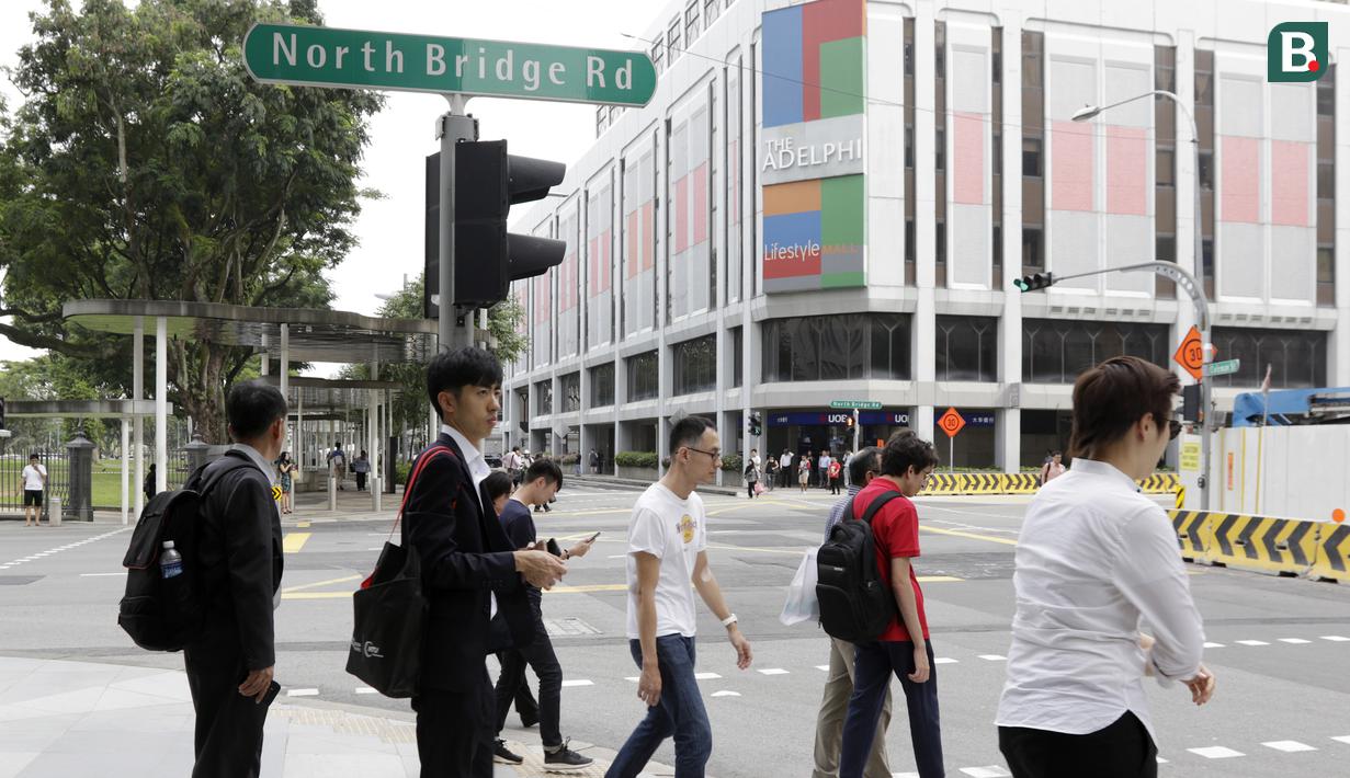 Sejumlah warga melintas di sekitar Hotel Peninsula Excelsior, Singapura, Rabu (7/11). Hotel bintang empat ini menjadi tempat menginap Timnas Indonesia jelang Piala AFF 2018. (Bola.com/M. Iqbal Ichsan)