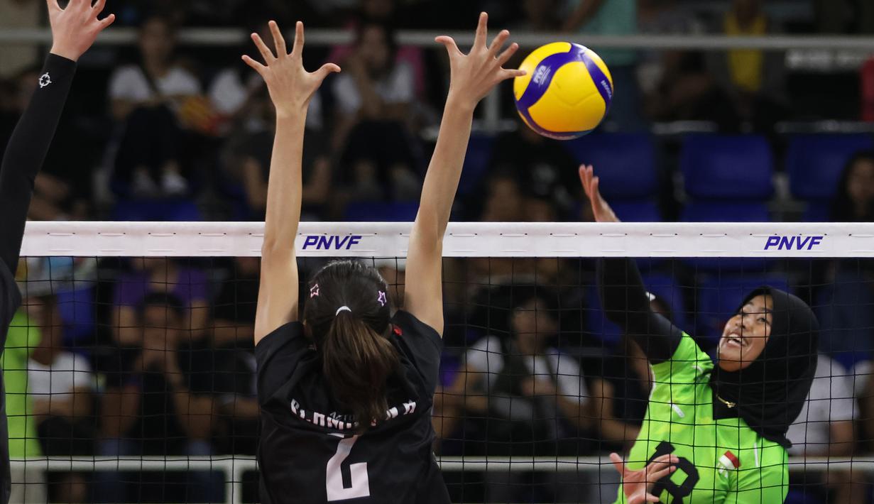 <p>Pemain Timnas voli putri Indonesia, Putri Agustin (kanan) melepaskan spike yang berusaha diblok pemain Singapura, Nadja Kim Schmidt pada laga Grup B AVC Challenge Cup 2024 di Rizal Memorial Coliseum, Manila, Filipina, Jumat (24/5/2024). Indonesia menang 3-0 (25-14, 25-13, 25-14). (Asian Volleyball Confederation)</p>