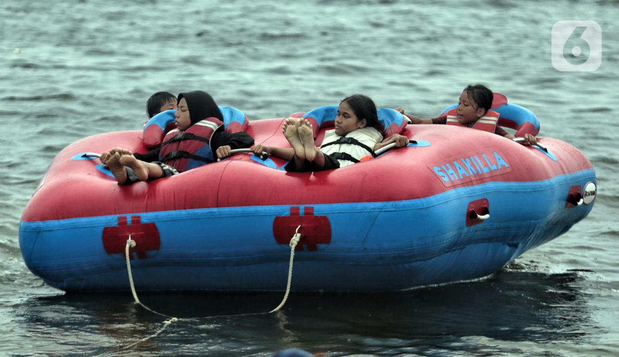 Wisatawan menaiki wahana saat mengisi libur Natal di Pantai Ancol, Jakarta, Minggu (25/12/2022). Kepala Komunikasi PT Pembangunan Jaya Ancol Ariyadi Eko Nugroho mengungkapkan per hari ini jumlah wisatawan di Taman Impian Jaya Ancol tembus 40.000, angka tersebut meningkat dua kali lipat dibanding libur hari biasa maupun Natal tahun 2021. (merdeka.com/Iqbal S. Nugroho)
