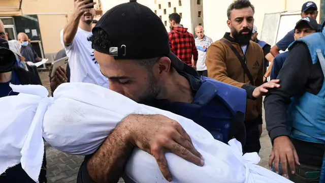 Mohammed Alaloul menangis ketika dia memeriksa jenazah keempat putranya di Rumah Sakit Al-Aqsa
