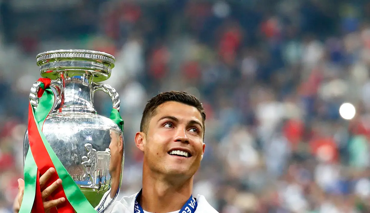 Cristiano Ronaldo membawa tropi Piala Eropa 2016 usai memenangkan laga melawan Prancis di Stade de France, Senin (11/7). Ronaldo menjadi Pencetak Gol Terbanyak sepanjang perhelatan Piala Eropa berlangsung sebanyak 9 gol. (REUTERS)