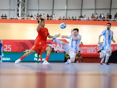 Pemian Timnas Futsal Indonesia, Israr Megantara (kiri) berebut bola dengan pemain Argentina, Agustin Raggiati dalam laga lanjutan 4 Nations World Series 2025 di Jakarta International Velodrome, Rawamangun, Sabtu (01/02/2025). (Bola.com/Bagaskara Lazuardi)