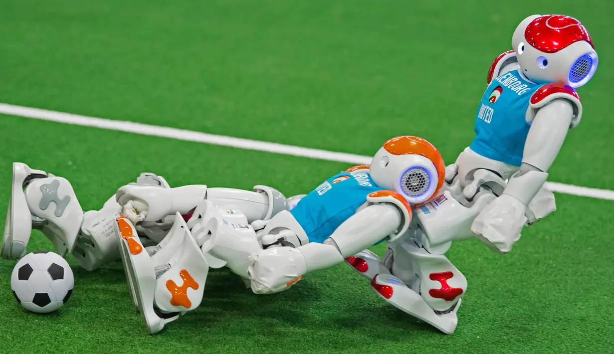 Robot tim Italia, nomadZ (kiri) melawan robot tim Luxembourg saat bertanding sepak bola pada ajang 'RoboCup German Open 2017' di Magdeburg, Jerman, Minggu (7/5). Sekitar 200 tim dengan 1000 peserta dari 15 negara mengikuti ajang ini. (AP Photo/Jens Meyer)