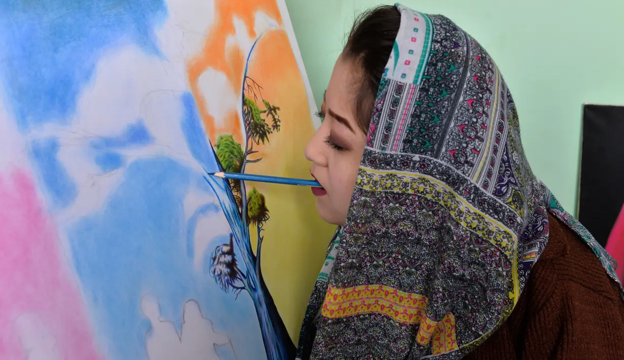 Foto yang diambil pada 5 Desember 2019 menunjukkan seniman Robaba Mohammadi melukis menggunakan mulut di studionya di Kabul. Untuk membuktikan bahwa stigma negatif tentang perempuan dan disabilitas salah, Robaba mengembangkan bakat di bidang seni lukis. (NOORULLAH SHIRZADA/AFP)