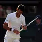 Petenis Serbia, Novak Djokovic meringis kesakitan saat melawan Tomas Berdych (Ceko) pada perempatfinal Wimbledon 2017, Rabu (12/7). Melawan Berdych cedera Djokovic kambuh, ia  terlihat mengalami masalah dengan cedera lengannya. (Gareth Fuller/PA via AP)