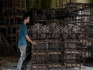 Seorang pekerja merapikan stand yang terbuat dari rotan yang digunakan untuk hadiah selama bulan suci Ramadhan di gudang home industri di Banda Aceh (24/4/2021). (AFP/Chaideer Mahyuddin)