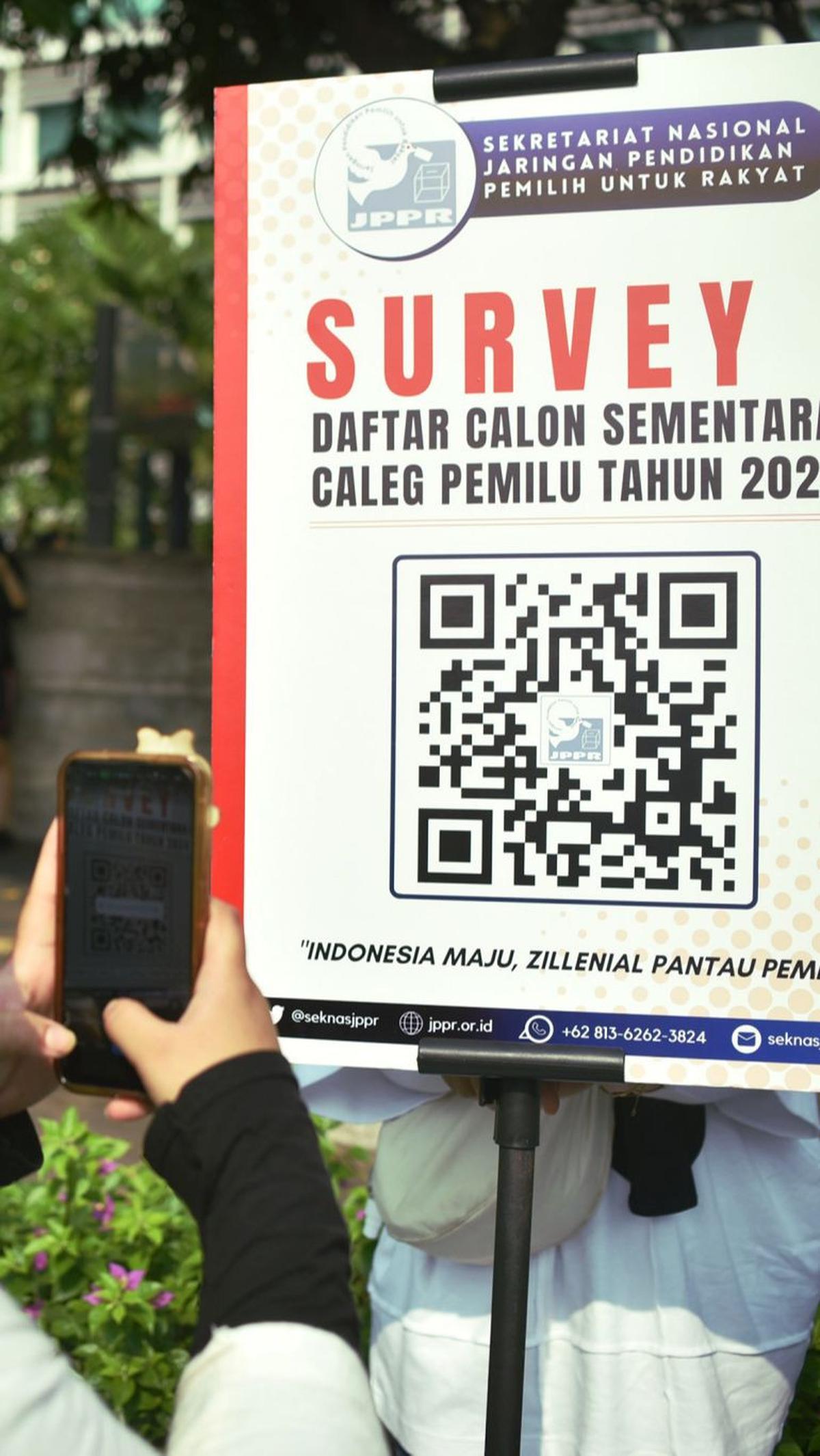 Seorang warga memindai barcode untuk mengecek daftar calon sementara caleg Pemilu 2024.