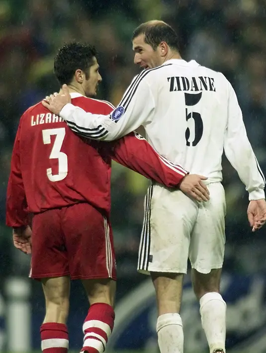 Pemain Real Madrid Zidane (kanan) berjalan bersama pemain Bayern Munchen, Lizarazu saat pertandingan leg kedua perempat final Liga Champions di Stadion Santiago Bernabeu di Madrid (10/4/2002). (AFP PHOTO / FRANCISCO PASO)