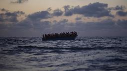 Imigran menunggu petolongan LSM Spanyol Open Arms di Laut Mediterania, Selasa (8/9/2020). Puluhan imigran termasuk wanita dan anak-anak asal Mesir, Maroko, Somalia, dan Sierra Leone menghabiskan lebih dari 20 jam saat melarikan diri dari Libya dengan kapal kayu. (AP Photo/Santi Palacios)