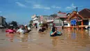 Sejumlah warga berjalan di genangan banjir yang merendam kota Bandung, Jawa Barat, Minggu (13/3). Kawasan Bandung Selatan kembali dilanda banjir akibat luapan Sungai Citarum dan membuat lebih dari 3000 jiwa mengungsi. (Timur Matahari/AFP)