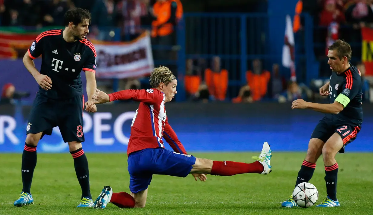 Penyerang Atletico Madrid, Fernando Torres (tengah) berusaha merebut bola yang dibawa bek Bayern Muenchen, Philipp Lahm di leg pertama liga champions di Vicente Calderon, Madrid, (28/4). Atletico menang atas Muenchen dengan skor 1-0. (Reuters/Paul Hanna)