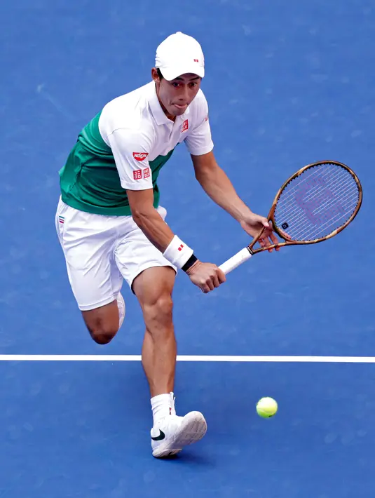 Petenis Jepang, Kei Nishikori melakukan servis saat bertanding melawan Marin Cilic dari Kroasia pada perempat final turnamen tenis AS Terbuka di New York, Rabu (5/9). Nishikori lolos ke semifinal dengan skor 2-6, 6-4, 7-6(5), 4-6, dan 6-4 (AP/Adam Hunger)