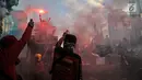 Sejumlah buruh menyalakan bom asap saat menutup aksi Hari Buruh Internasional di Jalan Medan Merdeka Barat, Jakarta, Rabu (5/1/2019). Buruh dari berbagai organisasi merayakan Hari Buruh Internasional di Kawasan Silang Barat Daya Monas. (merdeka.com/Iqbal S Nugroho)