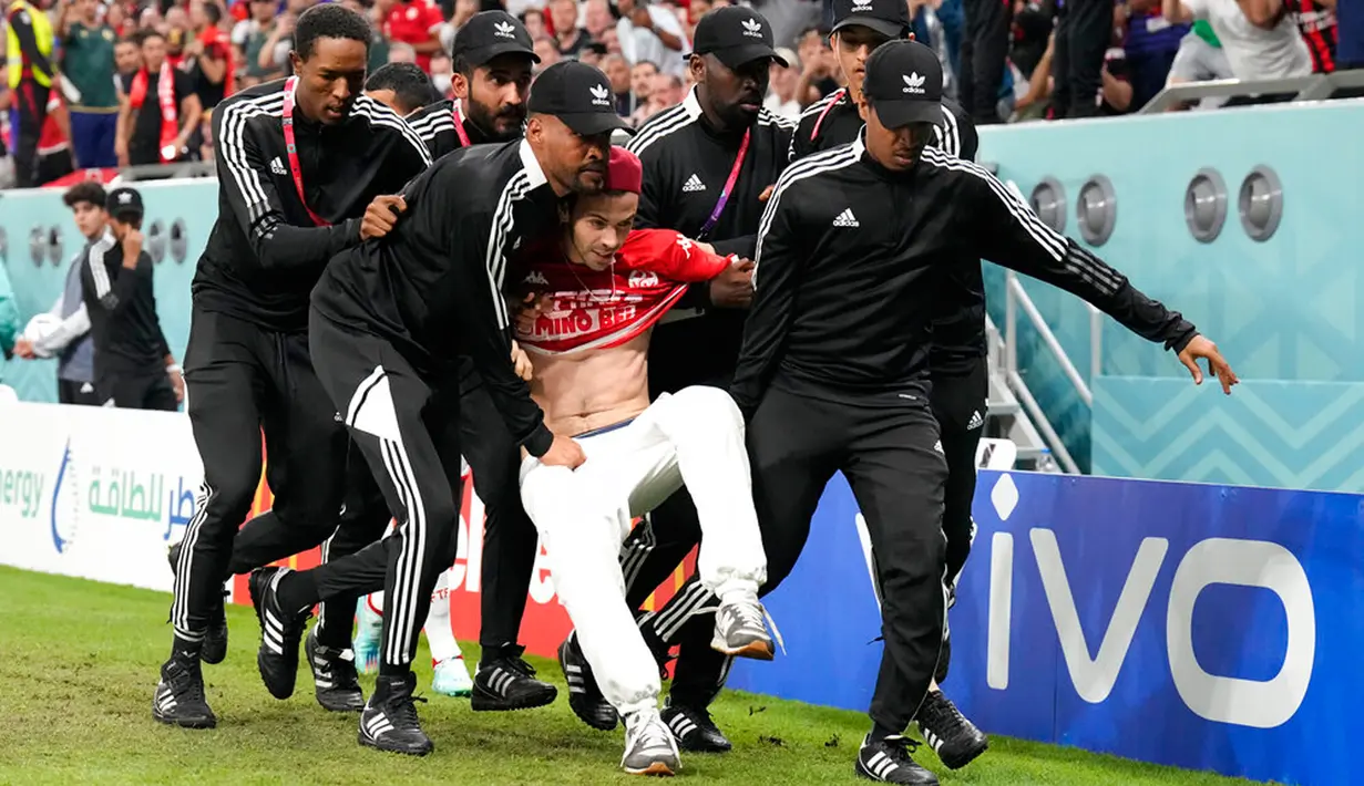Petugas keamanan membawa penyusup lapangan pada pertandingan sepak bola Grup D Piala Dunia 2022 antara Tunisia dan Prancis di Education City Stadium, Al Rayyan, Qatar, 30 November 2022. Banyak warganet merasa senang karena masalah Palestina bisa menjadi perhatian di Piala Dunia 2022. (AP Photo/Martin Meissner)