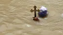 Seorang Kristen Ortodoks Moldovian membawa salib saat pembaptisan di perairan Sungai Yordan di dekat kota Jericho (4/3). Sungai ini diyakini menjadi tempat Yesus Kristus dibaptis oleh Yohanes Pembaptis. (AFP Photo/Gali Tibbon)
