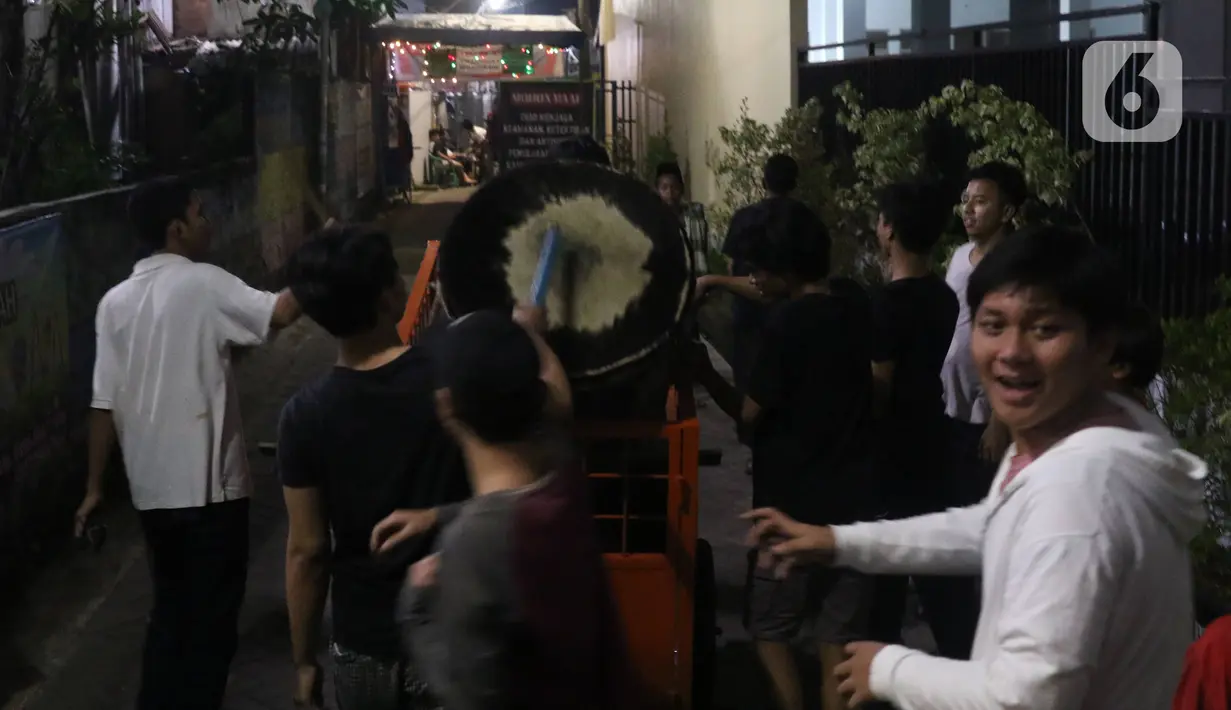 Sejumlah remaja melakukan pukul bedug keliling kampung di Karang Tengah,Tangerang, Banten, Rabu (29/4/2020). Pukul bedug keliling merupakan tradisi membangunkan warga untuk sahur pada bulan Ramadan. (Liputan6.com/Angga Yuniar)
