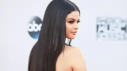 Penyanyi Selena Gomez berpose di red carpet ajang American Music Awards 2015 di Microsoft Theater, Los Angeles, Minggu (22/11). Selena tampil seksi dengan gaun merah yang mengekspos bagian punggungnya. (Mark Davis/Getty Images/AFP)