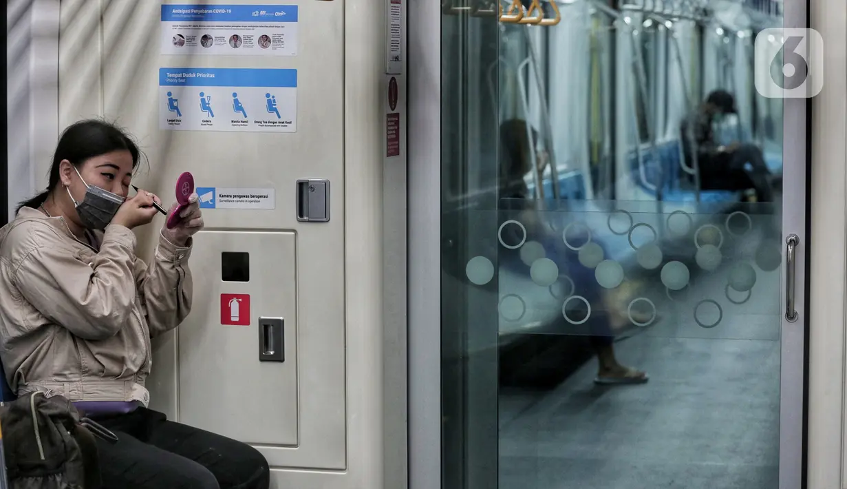 Penumpang berhias saat menaiki Moda Raya Terpadu (MRT) yang sepi saat Lebaran di Jakarta, Minggu (24/5/2020). Di tengah pandemi virus corona COVID-19, masyarakat yang biasanya menjadikan MRT sebagai sasaran wisata saat Lebaran kini terpantau sepi. (Liputan6.com/Johan Tallo)