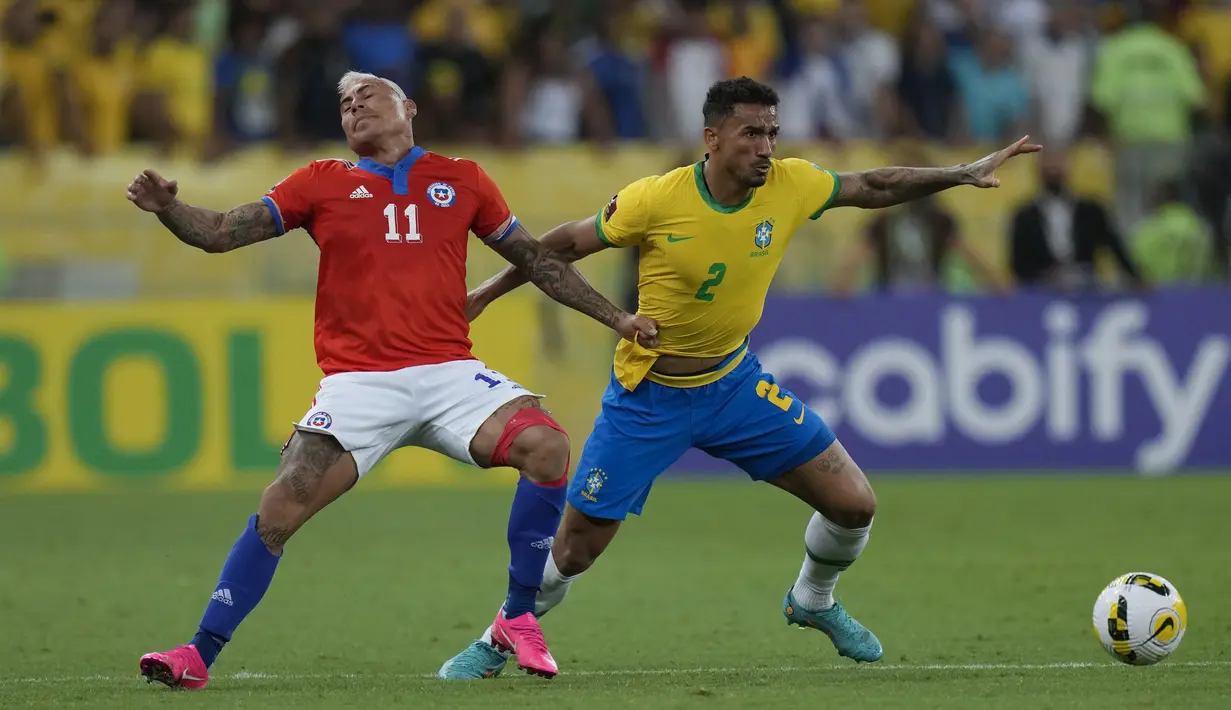 Gelandang Chile, Eduardo Vargas berebut bola dengan bek Brasil, Danilo selama pertandingan kualifikasi Piala Dunia 2022 zona CONMEBOL di stadion Maracana di Rio de Janeiro, Brasil, Jumat (25/3/2022). Brasil menang atas Chile 4-0.  (AP Photo/Silvia Izquierdo)